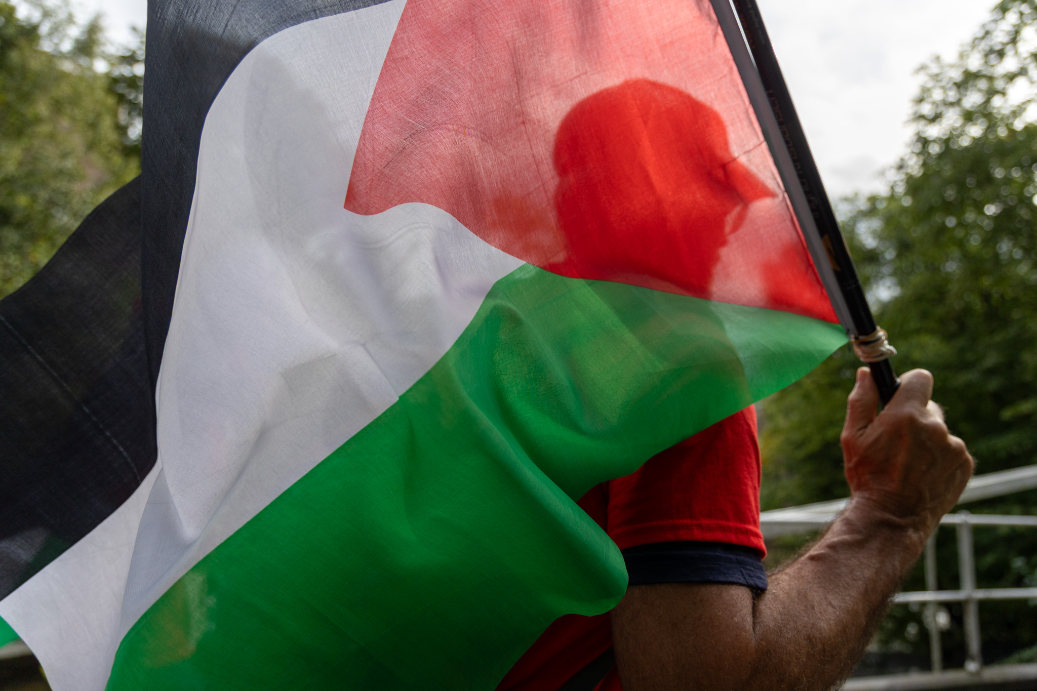 Mann holder Palestina-flagg mens han løper