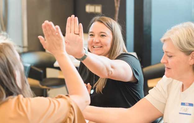 Image of happy employees high-fiving