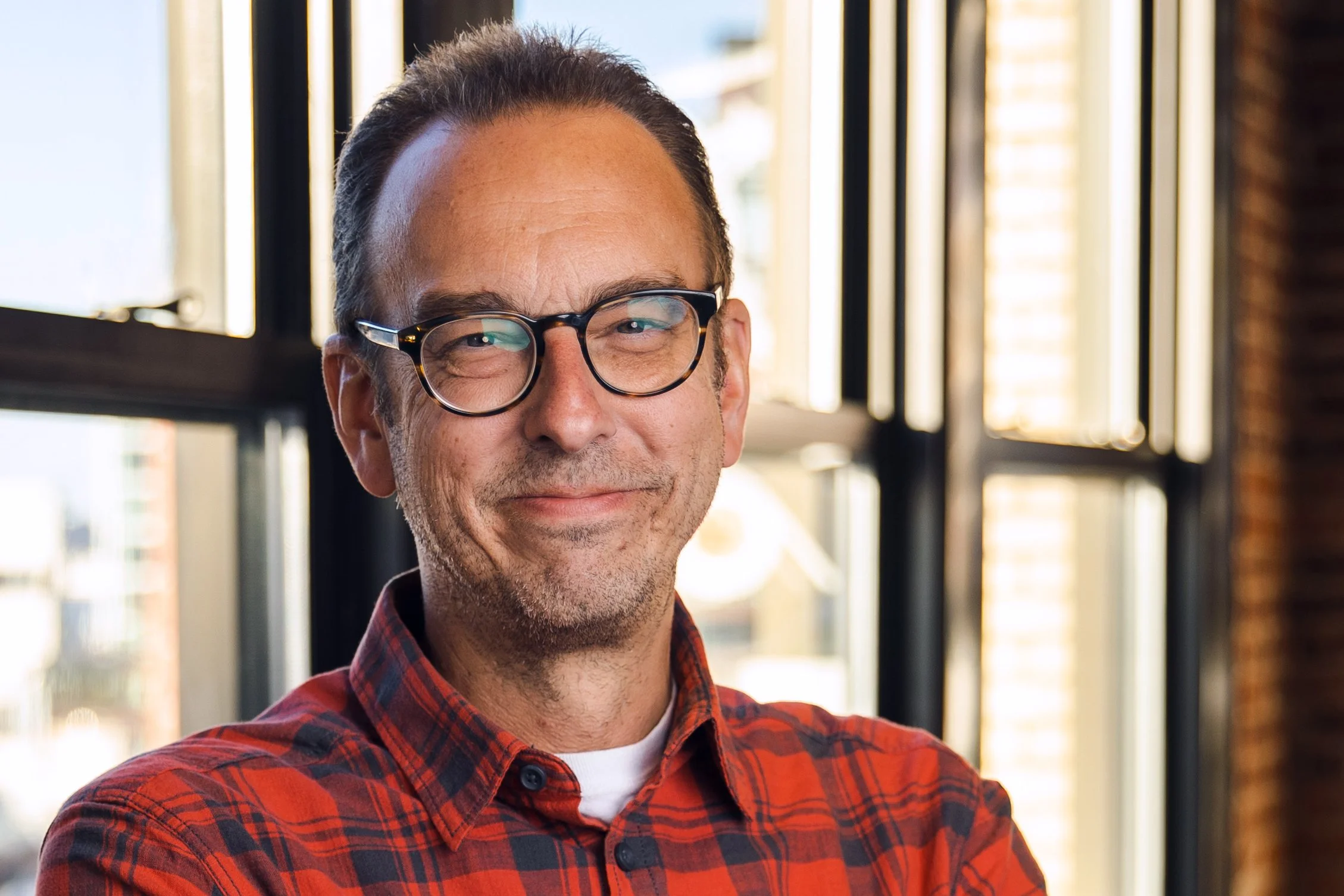 Lance Fensterman in a red shirt in front of a window