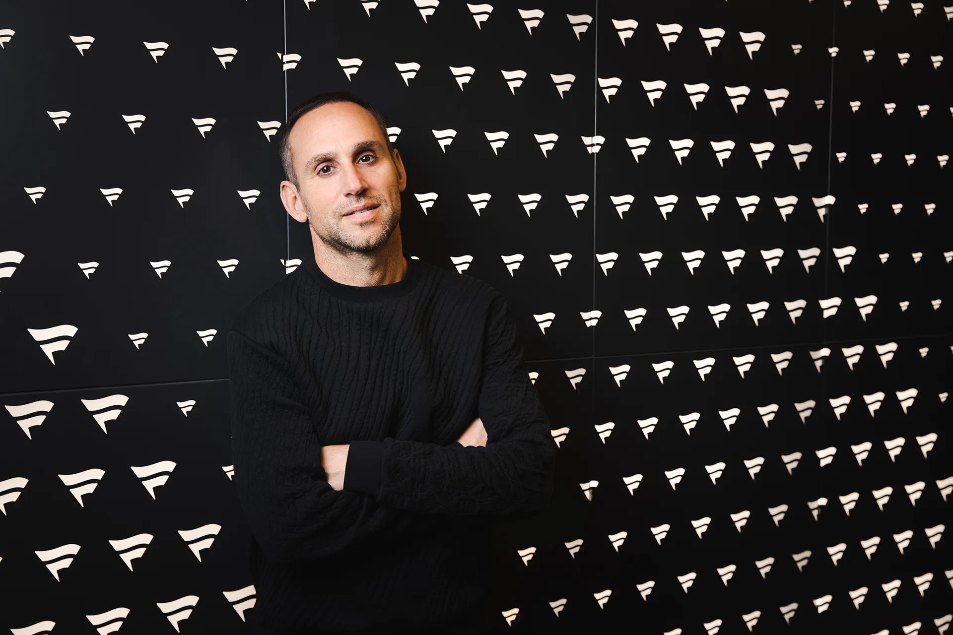 Michael Rubin against a black wall with Fanatics logos