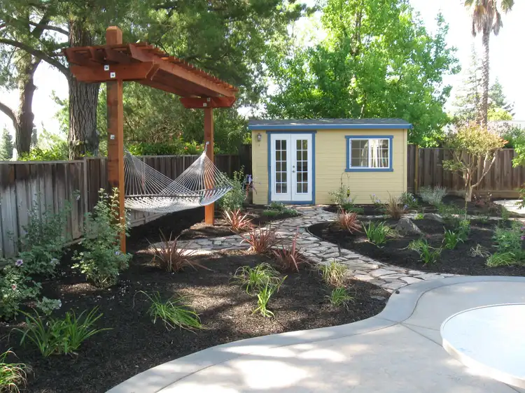 Home design photo. hammock in the background hanging above the landscaped path. freshly poured and cut concrete 