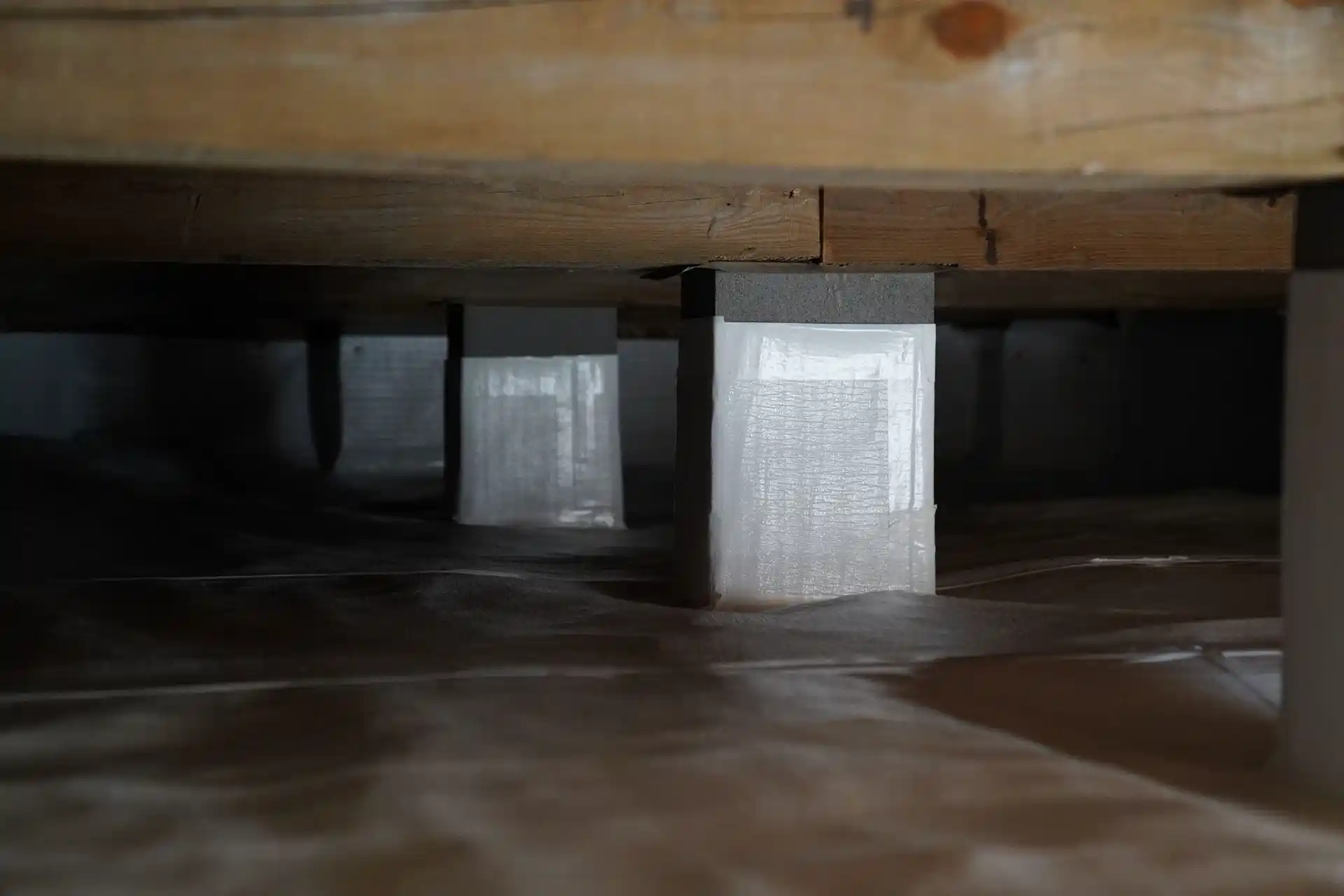 Crawl space encapsulation service with white liner and moisture barriers protecting Alabama home structure