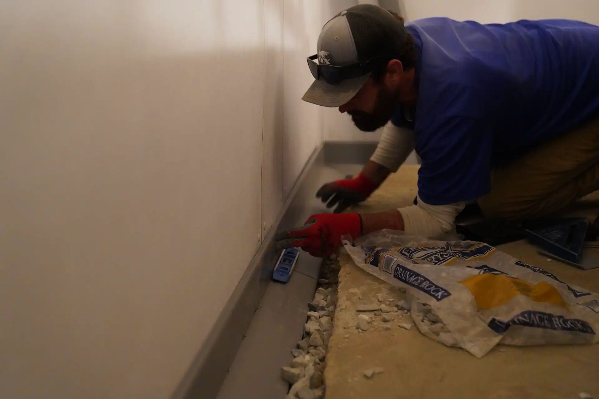 Footing drain and perimeter drainage tile system installation for foundation waterproofing in Alabama home