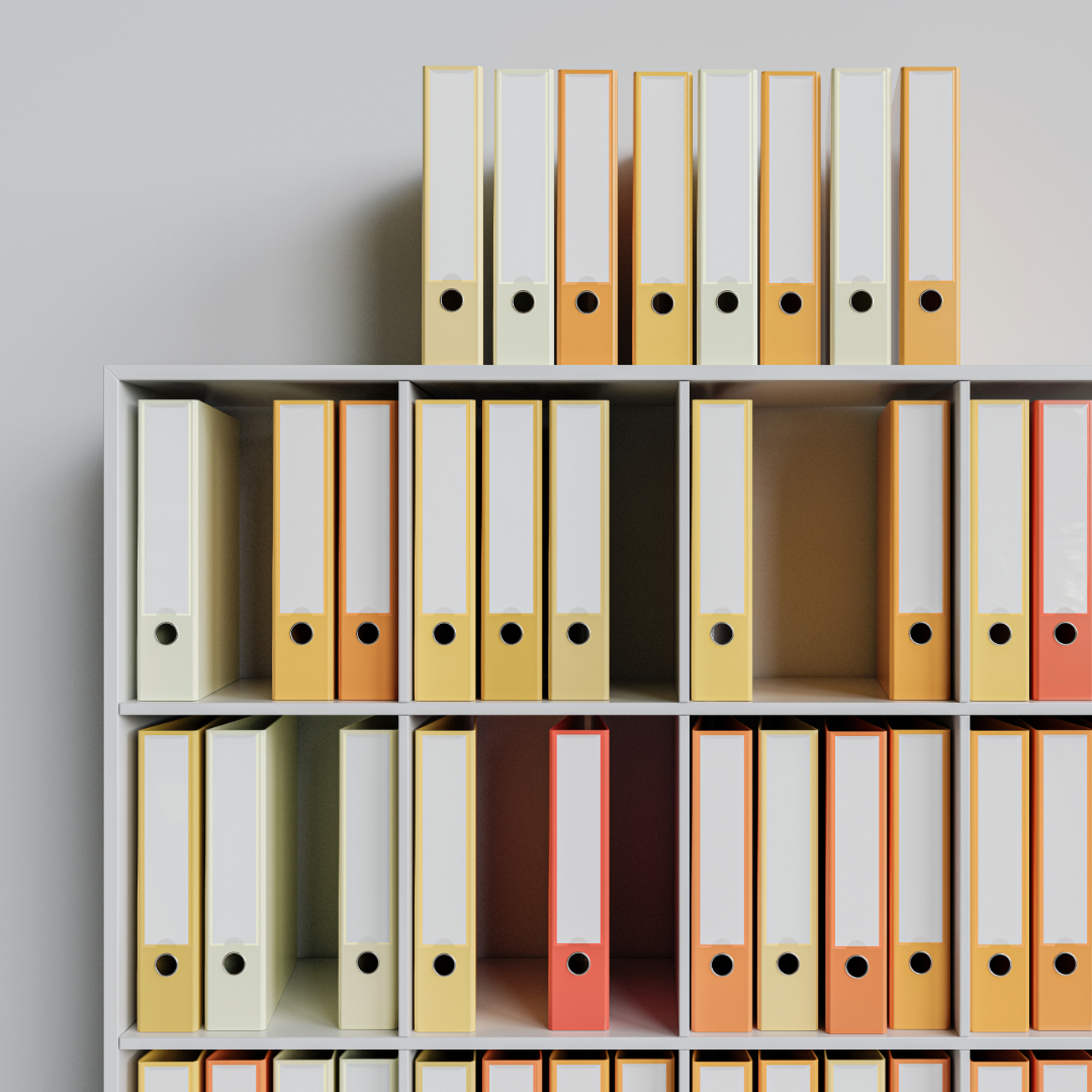 Shelving with yellow, orange, and red folders stacked on the shelves and on the top edge