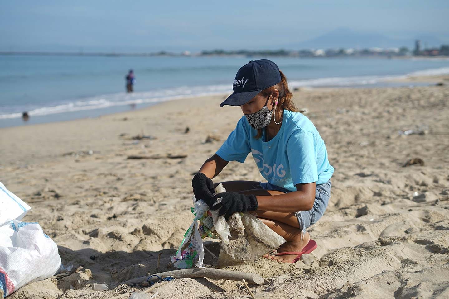 A girl collecting garbage on a beach