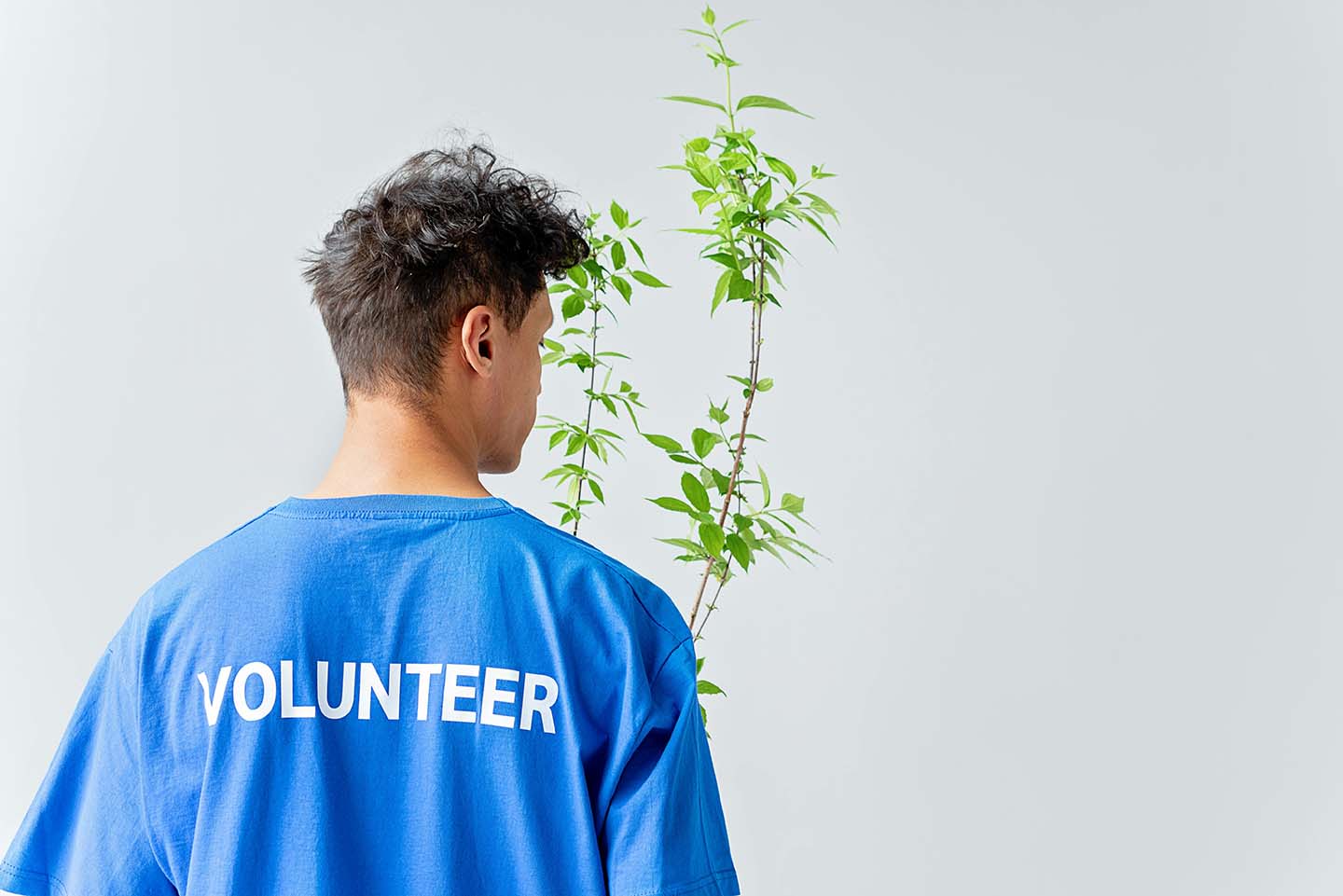 A man wearing a blue shirt with 'volunteer' printed on the back