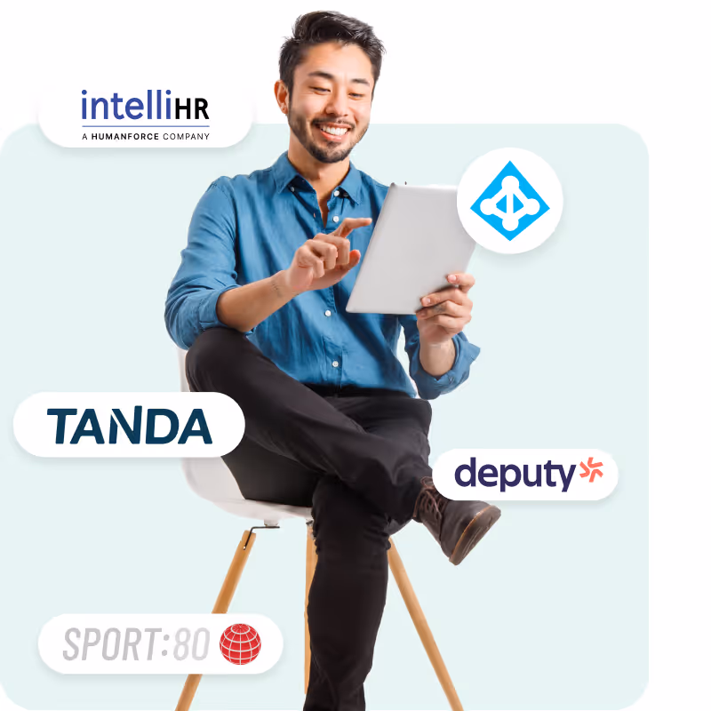 A young man sitting on chair with iPad in hand with logo elements floating around him such as Sport:80, intellHR and TANDA