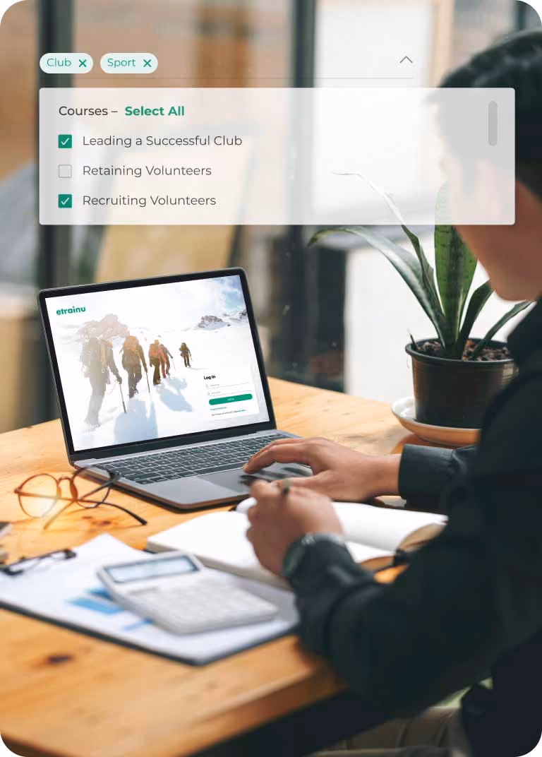 Person at a desk working on a laptop showing a website for club management courses.