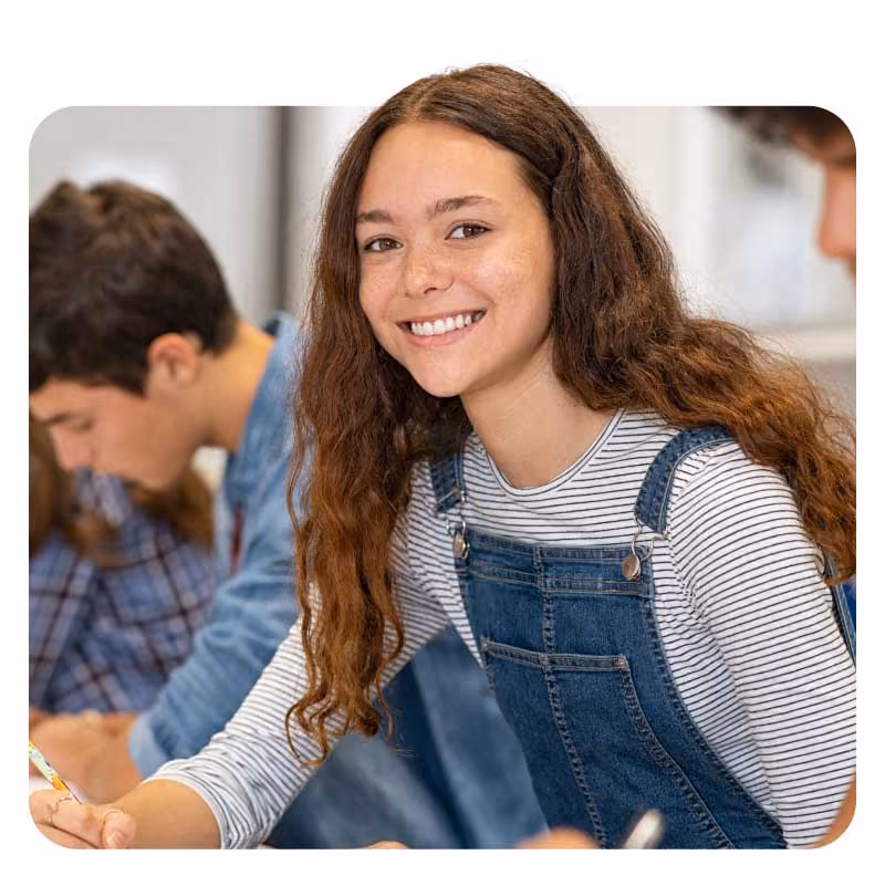 Students focused on writing in a classroom setting.