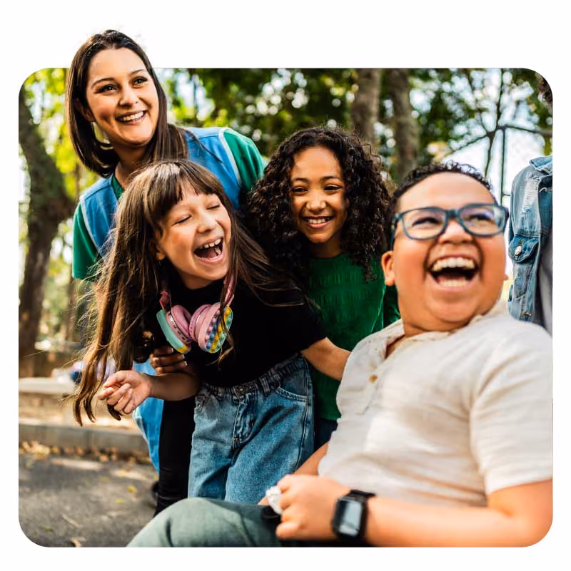 A group of children in casual clothes huddled together outdoors.