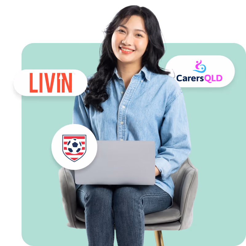 Person in a denim shirt using a laptop with various logos around them.