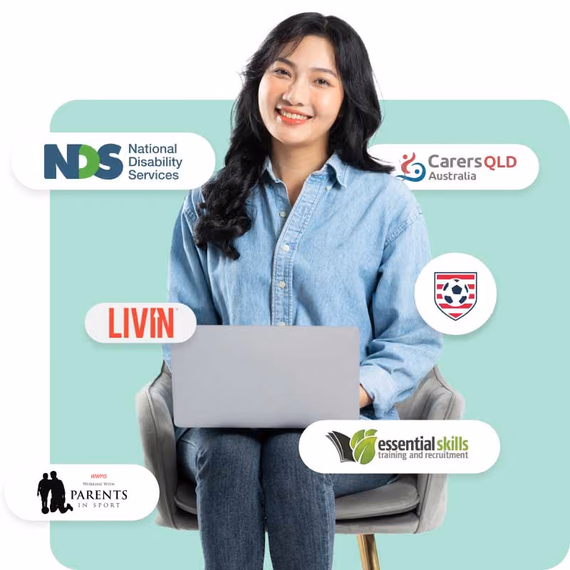 Person in a denim shirt using a laptop with various logos around them.