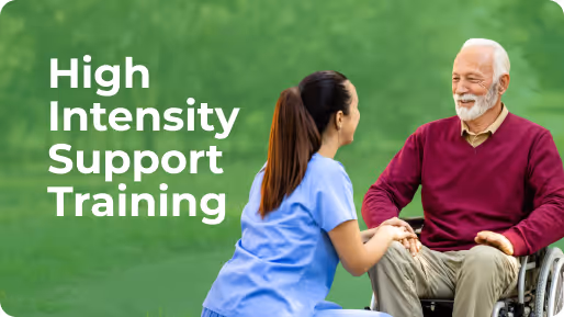 Healthcare worker kneeling and holding hands with an elderly man in a wheelchair outdoors with text 'High Intensity Support Training'.
