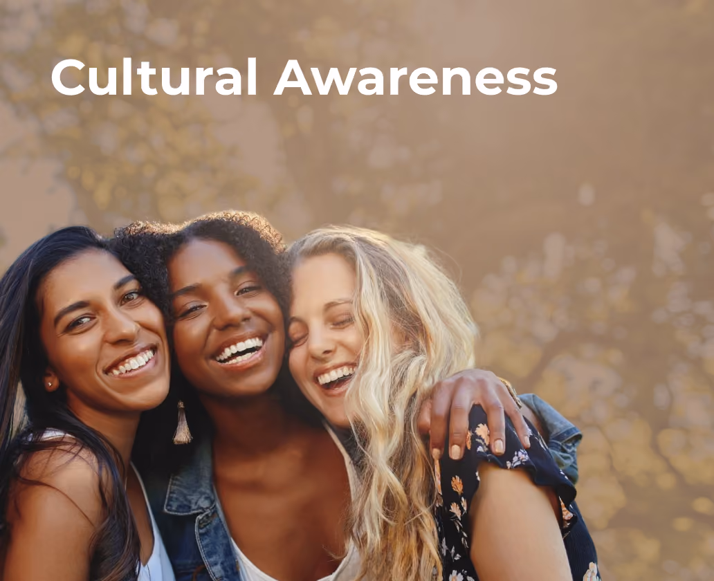 Three diverse women smiling and embracing each other with 'Cultural Awareness' text above.
