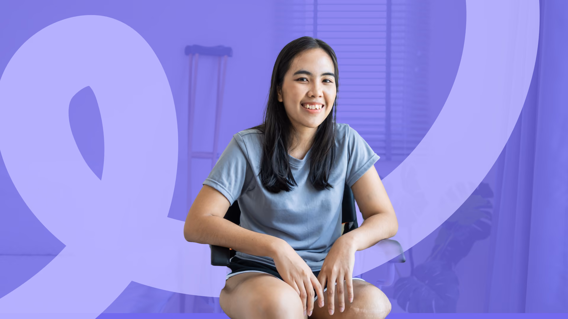 A smiling young woman sits on a chair, with a crutch visible in the background and a purple colour overlay.