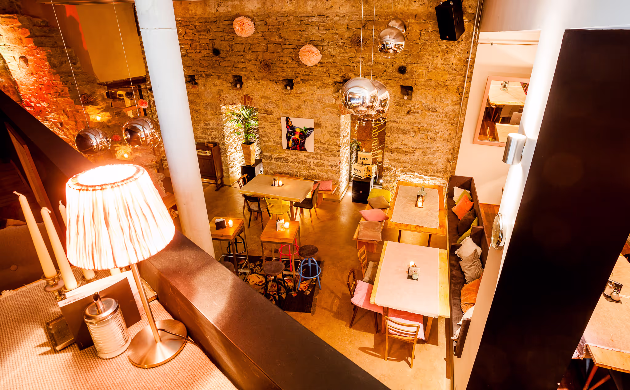 Stimmungsvolle Innenaufnahme eines modernen Restaurants mit rustikaler Steinwand und warmem Licht, fotografiert im Stil professioneller Corporate Fotografie.