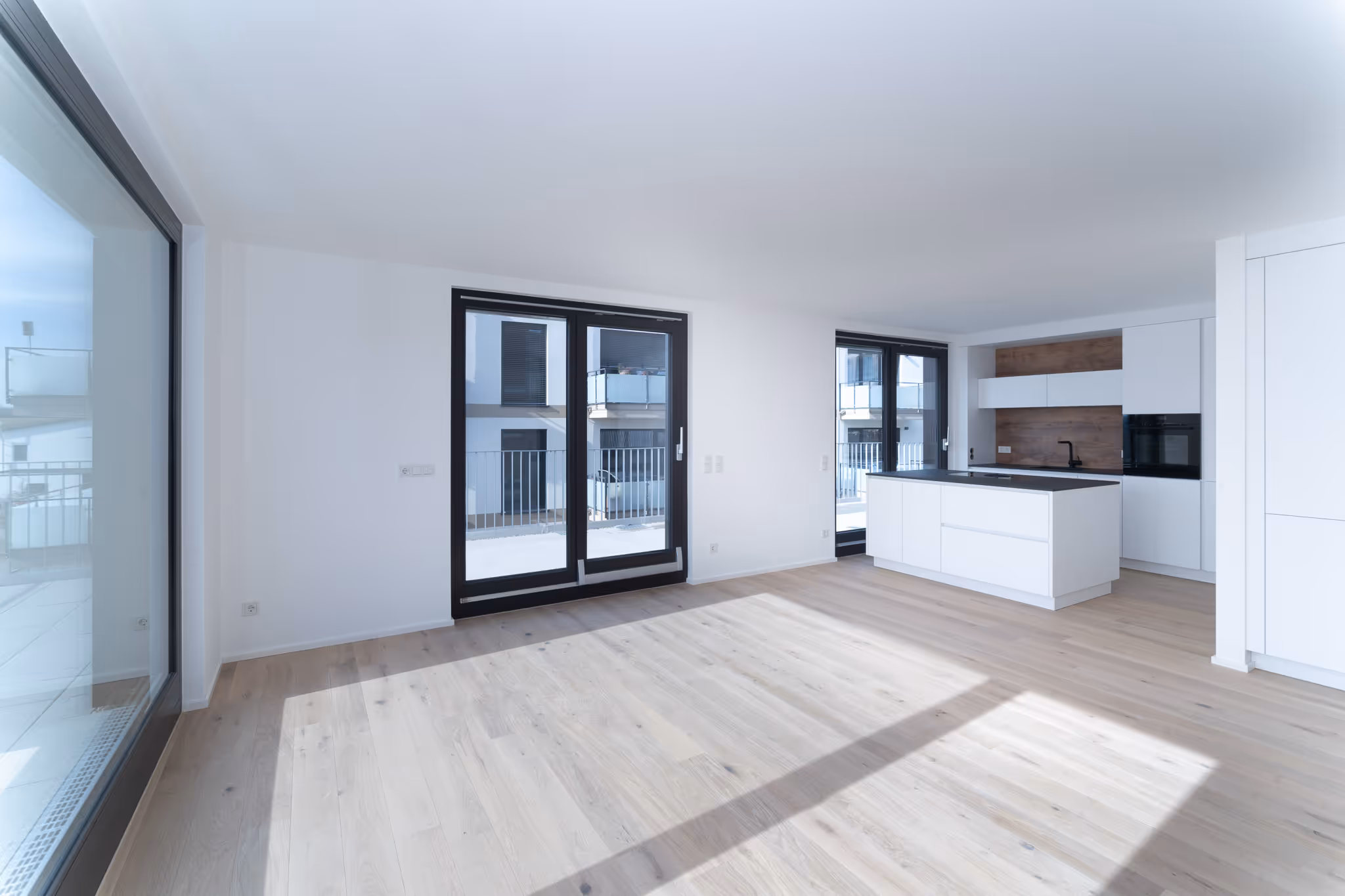 Real Estate Fotografie von Christian Meßner: hochwertig ausgestatteter Wohn- und Essbereich mit Designküche und viel Tageslicht