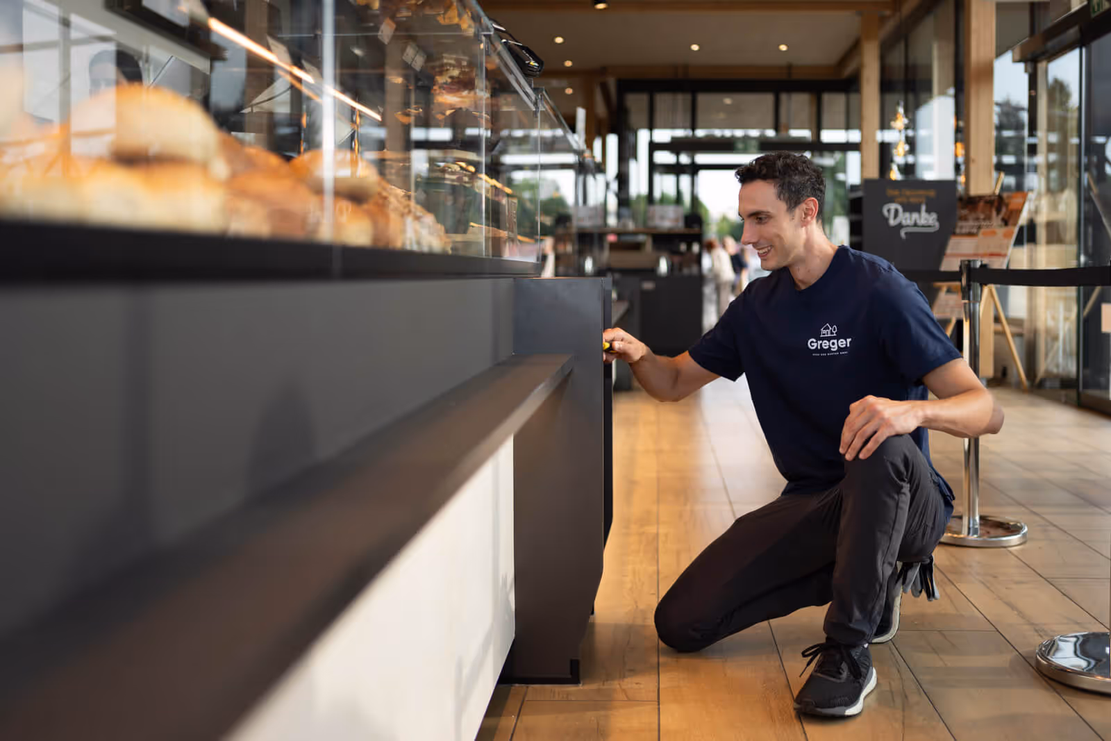 Corporate Fotograf begleitet einen Greger Haus und Garten Techniker bei der Arbeit in einer Bäckerei und zeigt präzise Handwerksarbeit im Alltag.