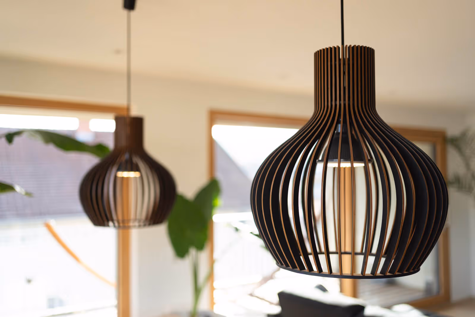 Detailaufnahme moderner Holzpendelleuchten in einem hellen Wohnzimmer, fotografiert von Immobilienfotograf Rottweil