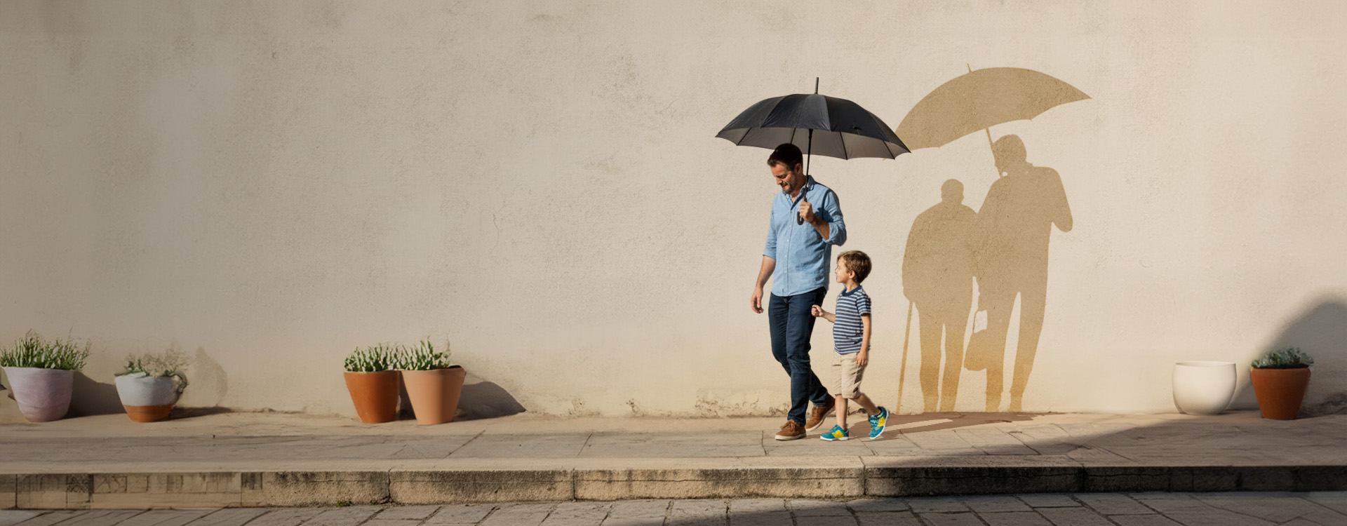 Father and son walking together holding an umbrella