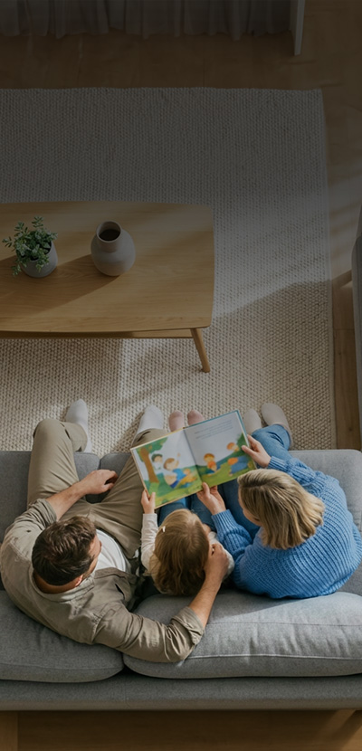 Family sitting on couch reading a book