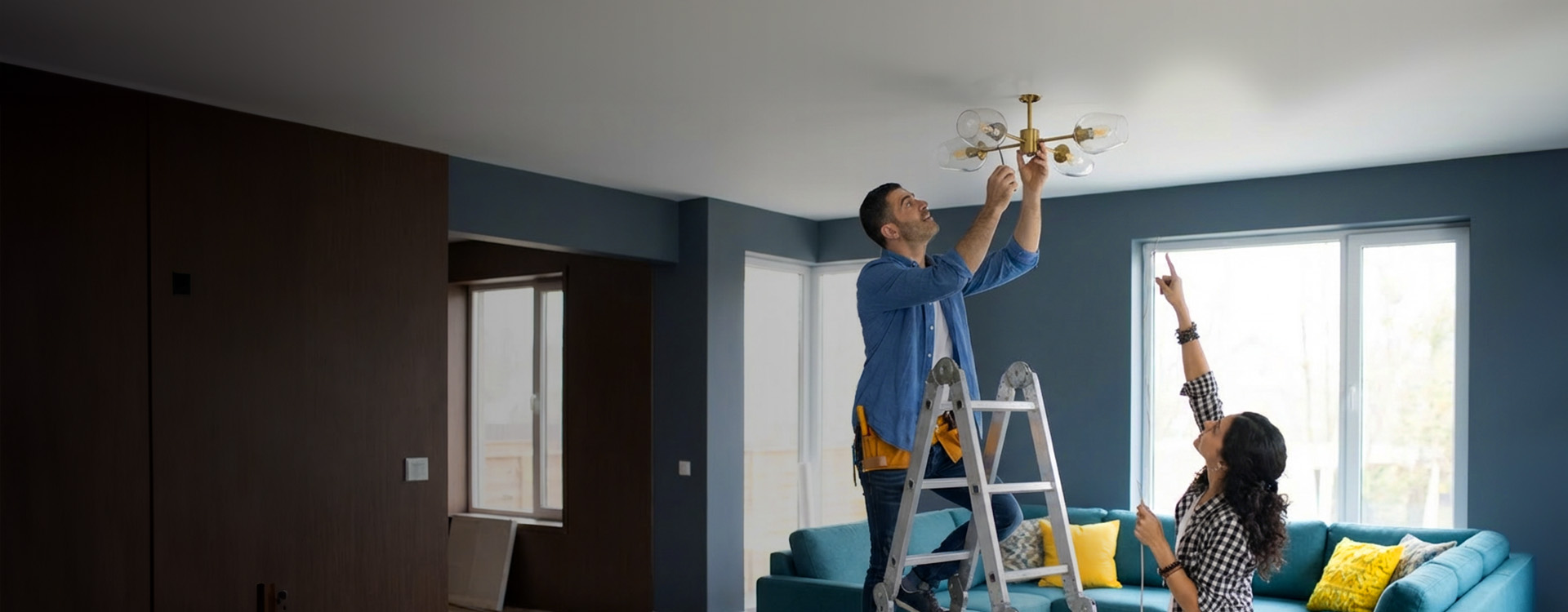 Husband hanging up a light with wife