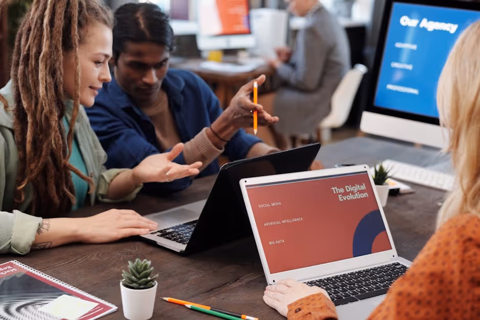 Diverse marketing team analyzing social media ad performance on laptop, office setting, 2024. - social media ad services