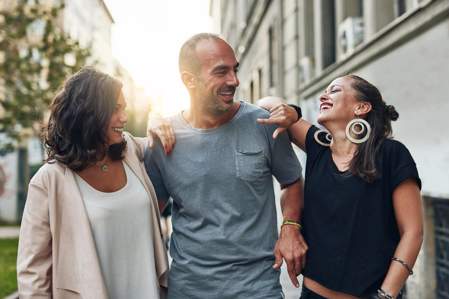 “Three friends walking together, smiling and connecting through an addiction recovery alumni program