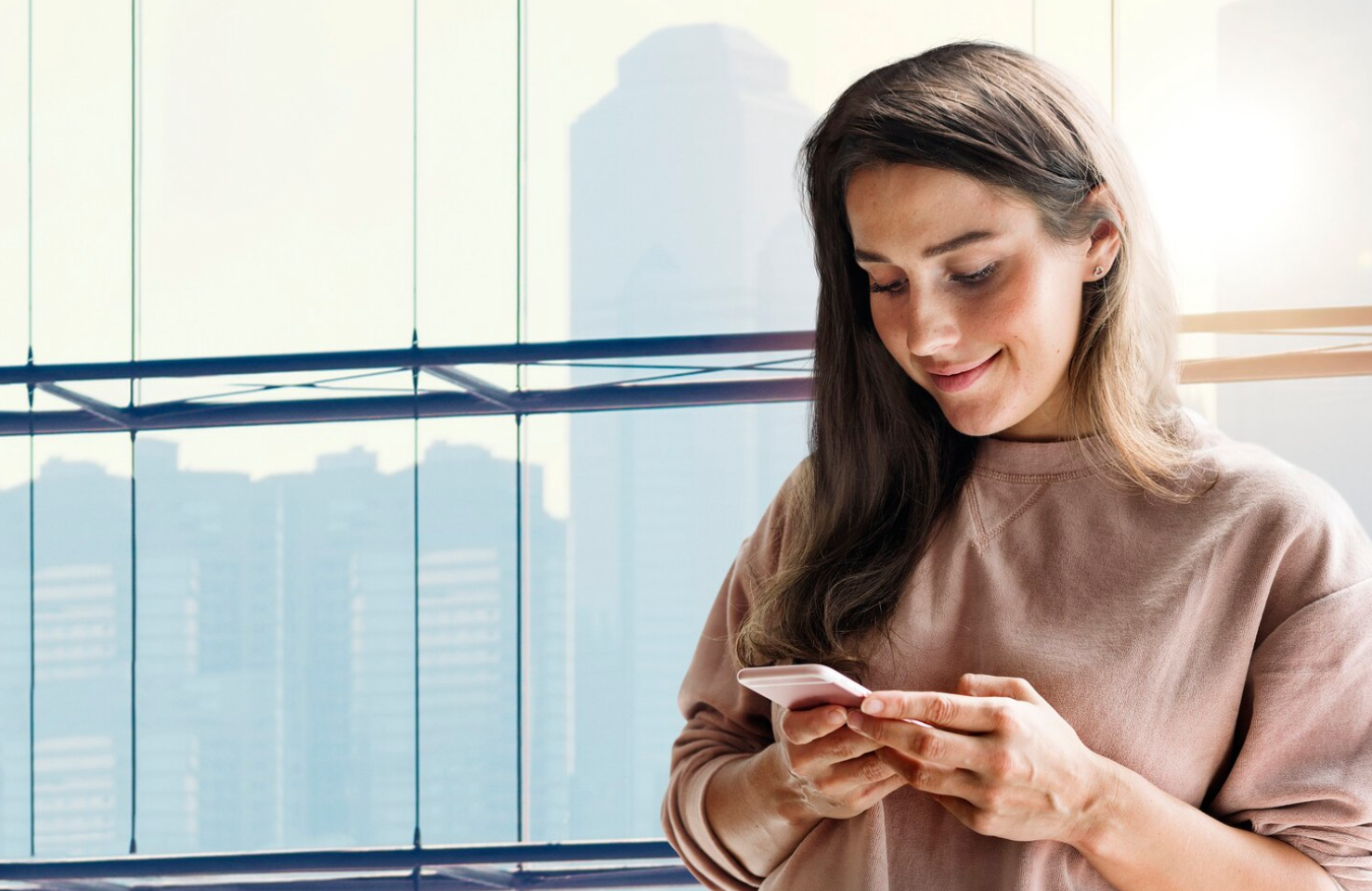 A woman inside a building browsing a rehab alumni app