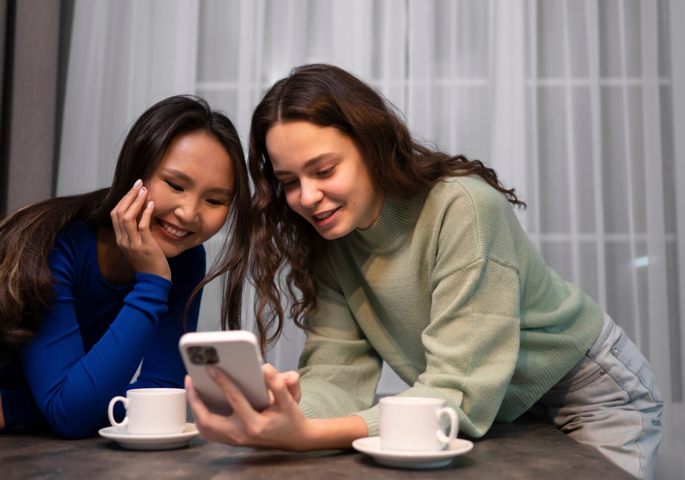 Two women reviewing content on a smartphone, representing mobile engagement in behavioral health alumni management