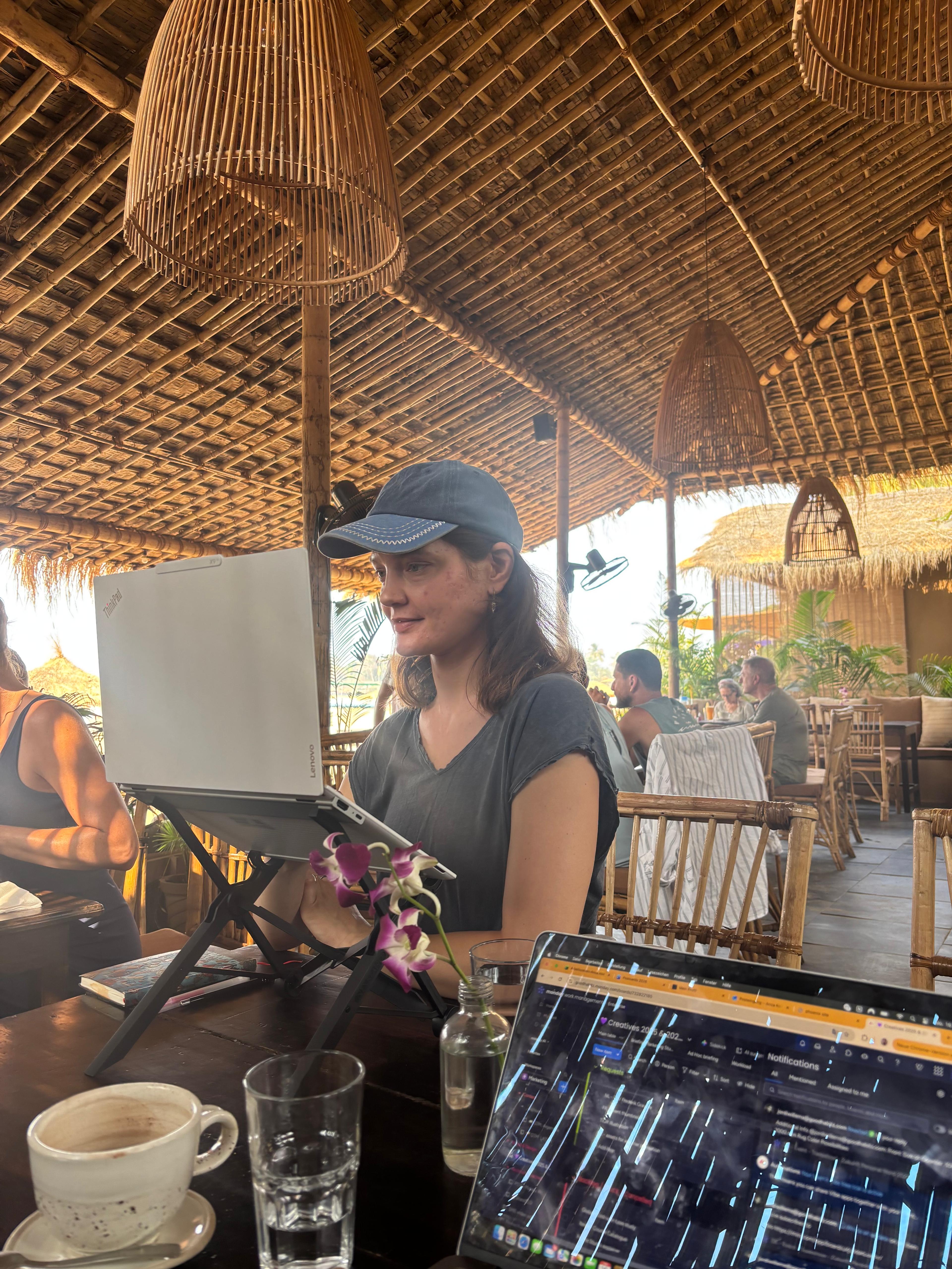 Magda Sokolovič working on her laptop at a cafe on the beach in Sri Lanka, building the Website Clarity Scanner automation