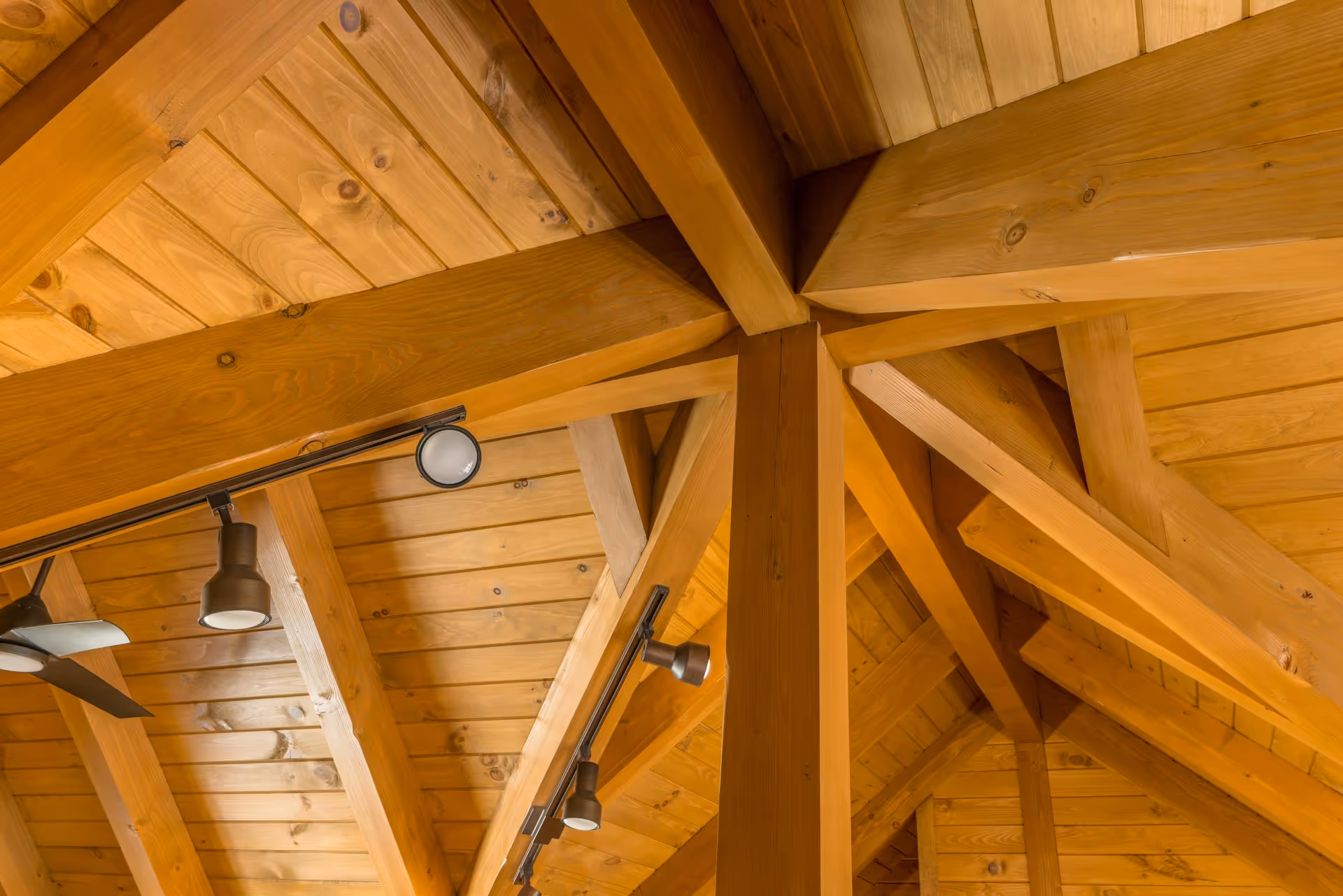 A pathway between stacked wood planks in a lumber yard, showcasing neatly organized log materials used for building custom homes and log cabins, including Amish homes.