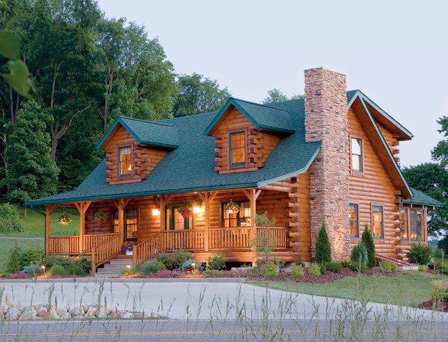 McKay Plan Model log home in Loudonville, Ohio, featuring dormer windows, a covered front porch, stone chimney, and green roof.
