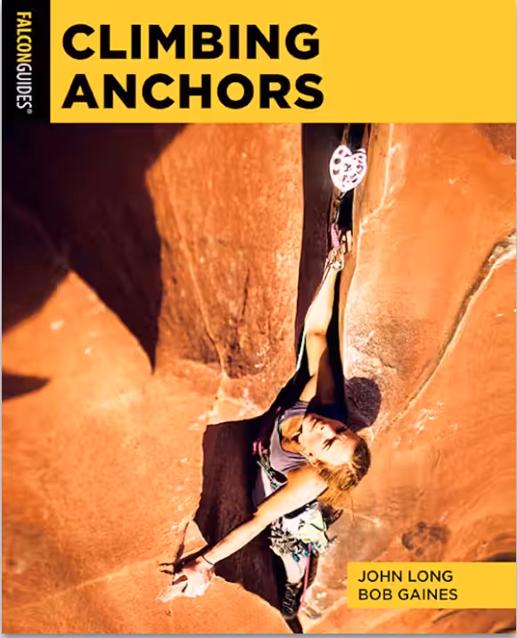 A person rock climbing using a camming device for safety on a steep, rocky surface.