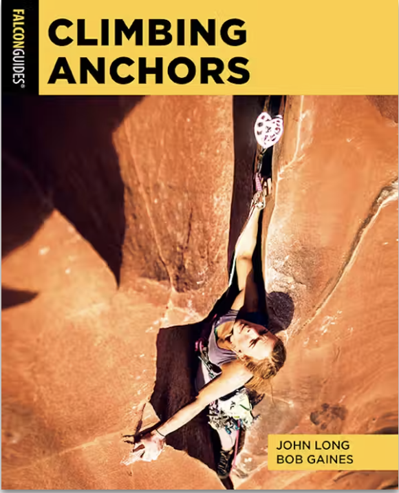 A person rock climbing using a camming device for safety on a steep, rocky surface.