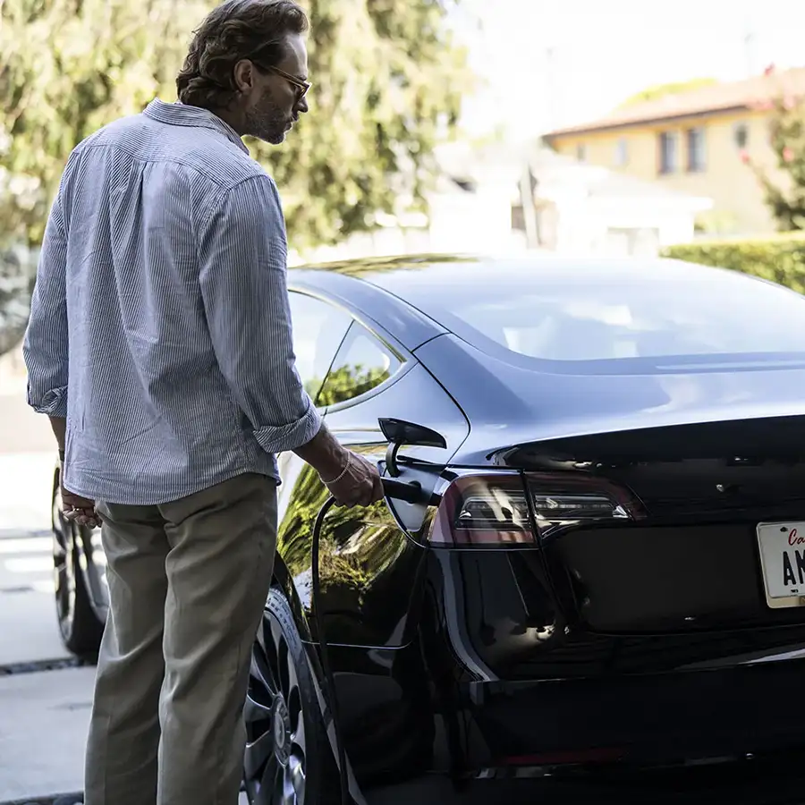 Man Charging Tesla with NACS EV Portable Charger by Ampure Charging
