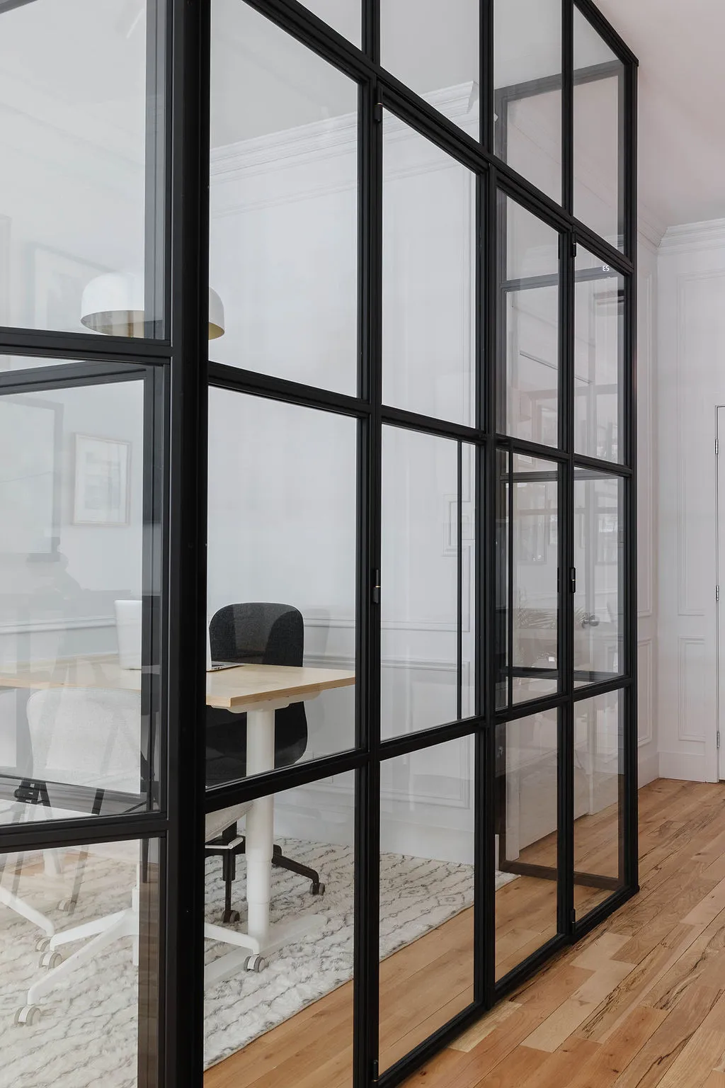 Cloison vitrée pour bureau à ossature noire séparant un espace de travail, réalisation Duques Simms