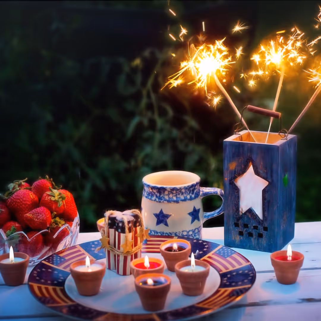 Plate of patriotic 4th of July decorated cookies including Uncle Sam hat, American flag, and red, white and blue star-shaped cookies with holiday decorations on bright red background