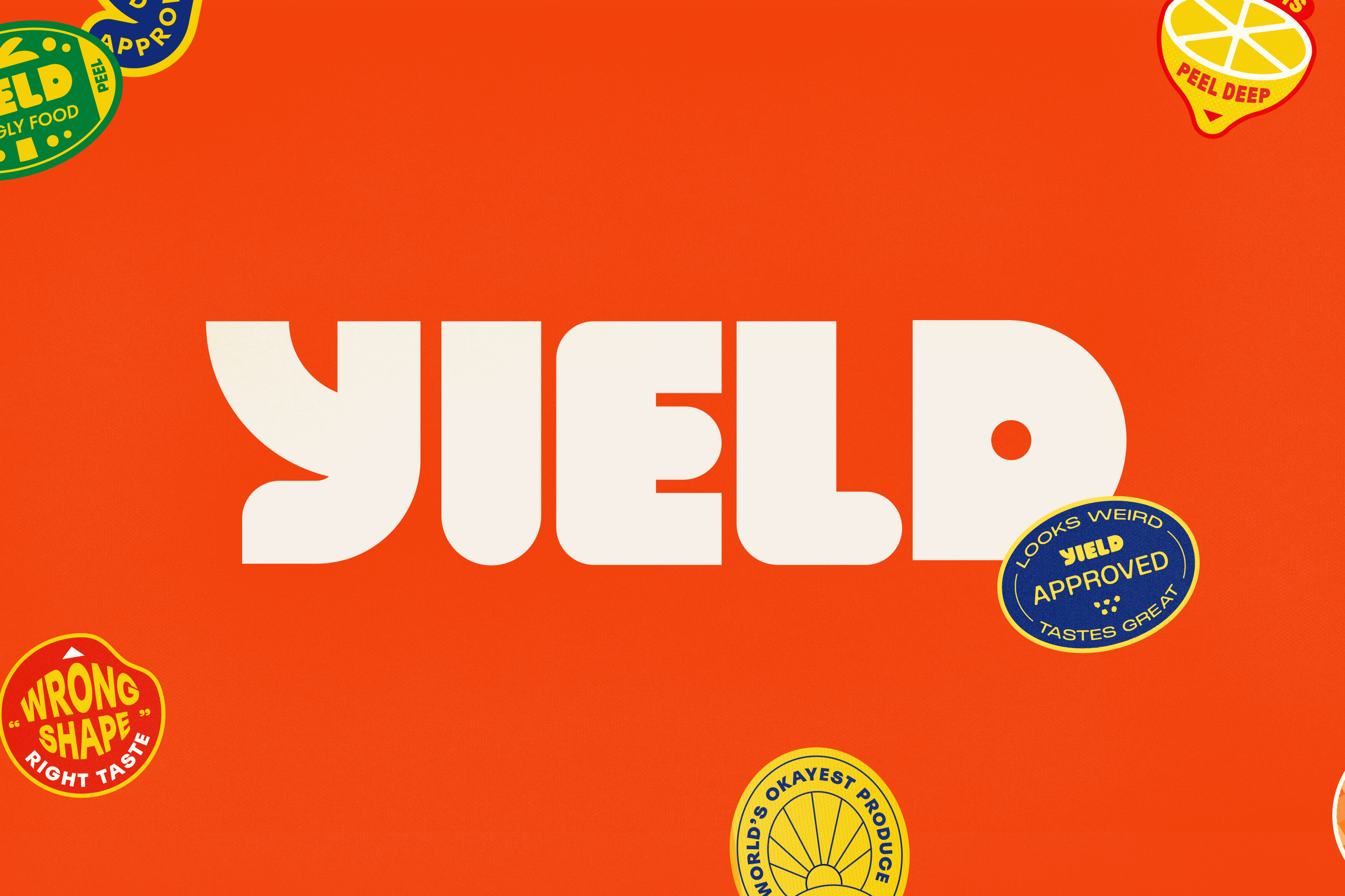 The word YIELD in large, bold white letters on an orange background surrounded by colorful badges with playful slogans like 'Wrong Shape Right Taste' and 'Yield Approved.'