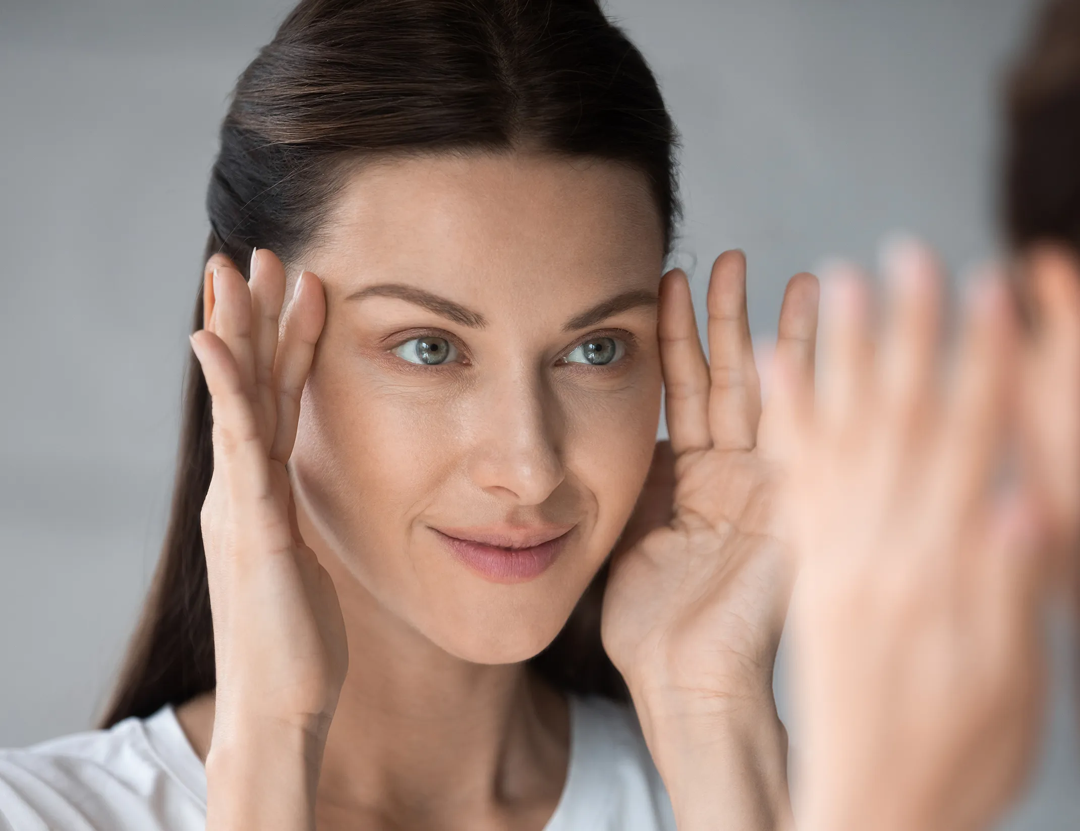 Woman looking at her reflection in the mirror