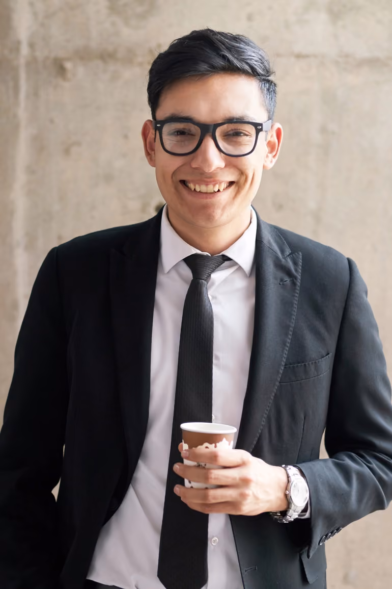 Young man in suit holding coffee