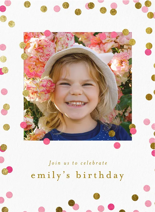 Smiling girl wearing a hat with flowers around her, framed by gold and pink confetti for a birthday.
