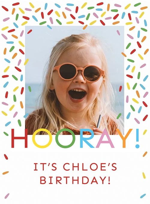 Smiling blonde girl wearing round pink sunglasses with "HOORAY! It's Chloe's birthday!" text and sprinkles.