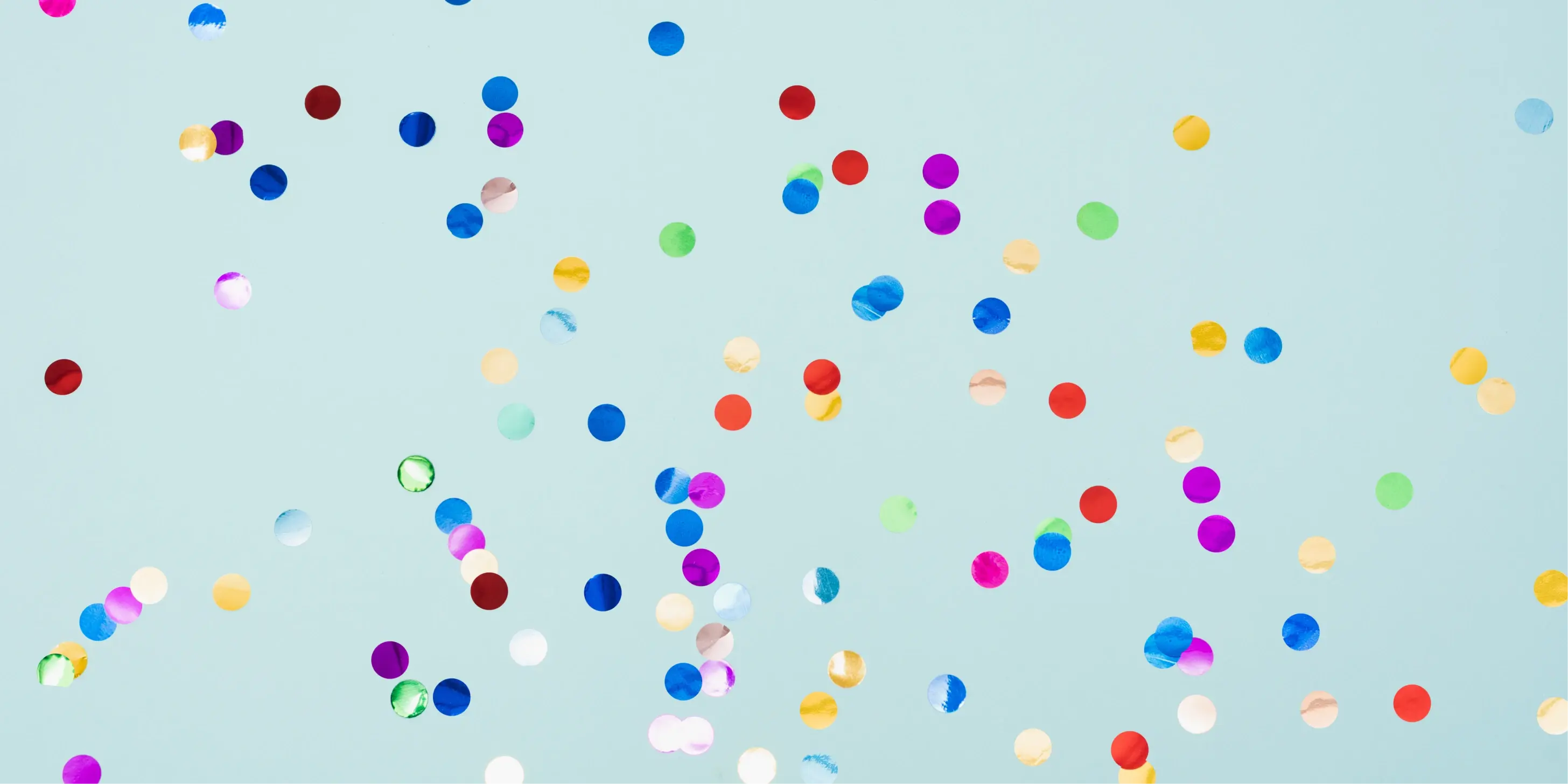 Colorful round confetti scattered against a light blue background.