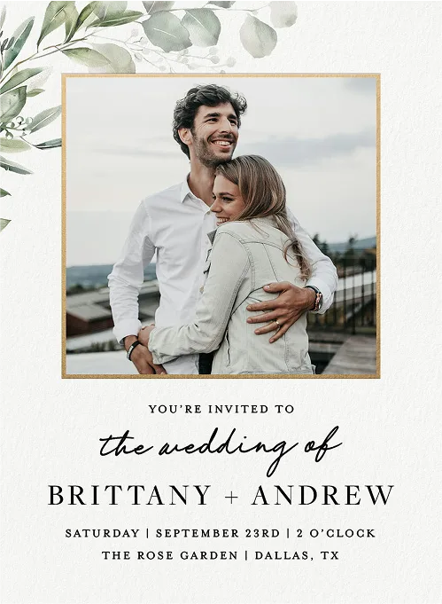 Wedding invitation with a couple hugging outdoors; event details below in elegant fonts.