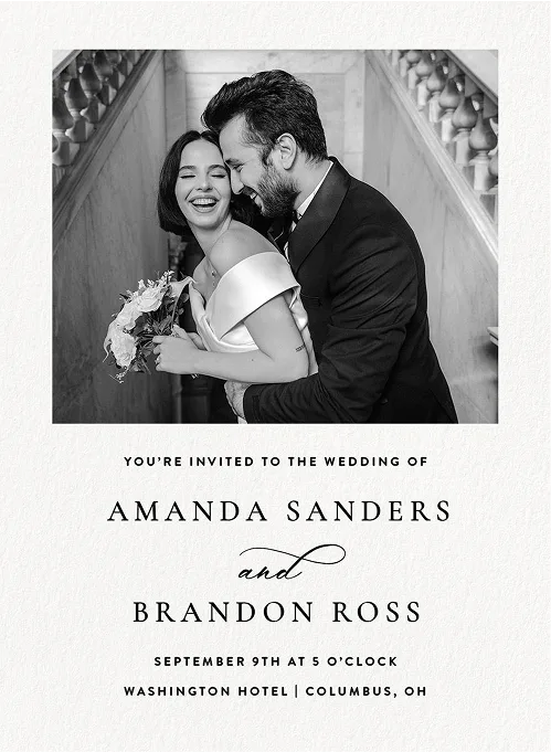 Smiling bride and groom embracing on staircase, wedding invitation for Amanda Sanders and Brandon Ross.
