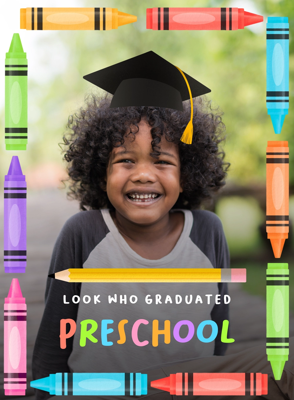 Smiling preschooler with curly hair wearing a graduation cap and colorful crayon border around text.