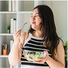 Young white woman easting a salad
