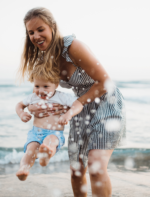 Mom and toddler playing at the ocean
