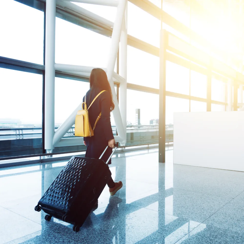 Mujer con maleta en un aeropuerto, representando la movilidad de la Golden Visa en España
